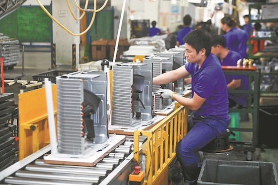 Des employés travaillent sur une cha ne de montage de climatiseurs à Cixi dans la province du Zhejiang (est de la Chine). (Photo/Xinhua)